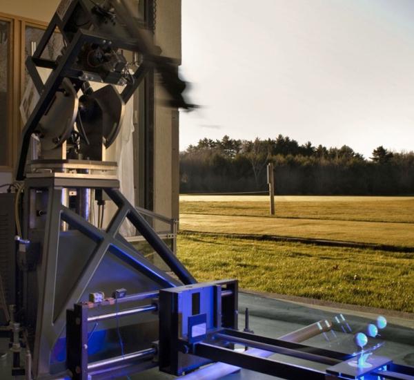 A robotic hitting machine drives a Titleist golf ball during product testing.