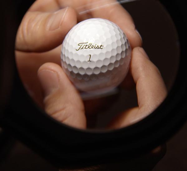 A Titleist R&D associate examines the dimple pattern on a new Titleist golf ball.